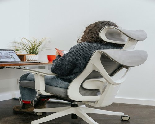 A focused individual organizing their desk ergonomics to maintain comfort and balanced posture during daily tasks